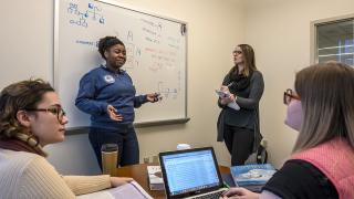 Four Simmons University graduate students in a classroom